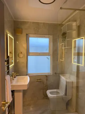 a bathroom with a toilet and a sink and a window at Cosy Greenwich Flat Near -Cutty Sark, River & Park in Moffat