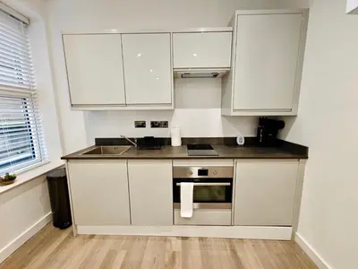 a kitchen with white cabinets and a stainless steel oven at Bright 2-Bed Apartment in Bury Town Centre in Moffat