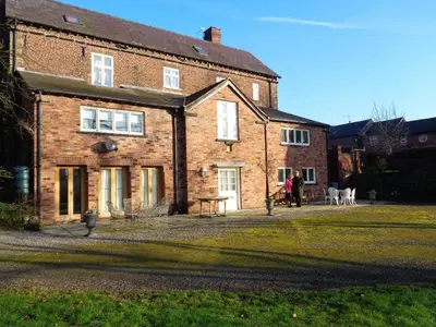a brick house with a table in front of it at Garden flat at Broomfield in Moffat