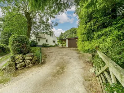 a dirt road in front of a white house at 3 Bed in Holmrook oc-sz537 in Beckfoot