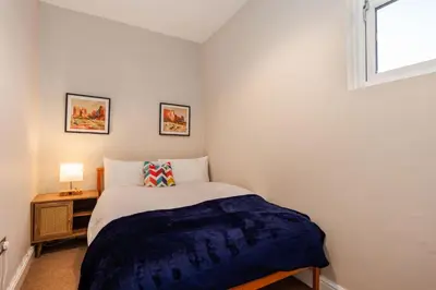 a small bedroom with a bed and a window at South Loft a Modern Apartment in Cockermouth in Cockermouth