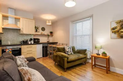 a living room with a couch and a kitchen at South Loft a Modern Apartment in Cockermouth in Cockermouth