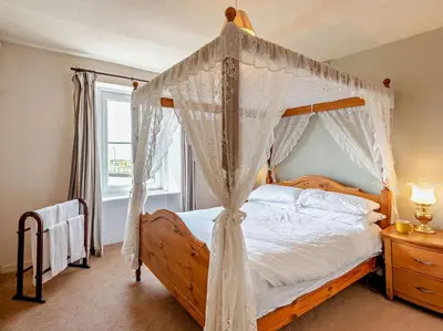 a bedroom with a canopy bed with white drapes at 3 Bed in Maryport oc-sz102 in Allonby