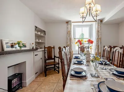 a dining room with a table and a fireplace at 3 Bed in Maryport oc-sz102 in Allonby