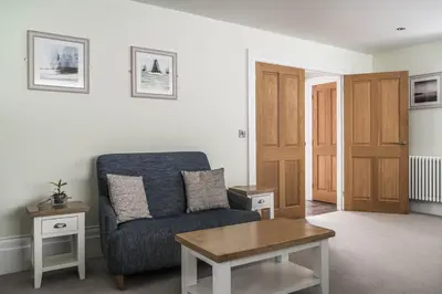 a living room with a chair and a table at Old School Mews - Shanklin - Dog Friendly in Moffat