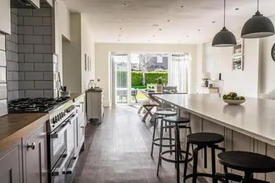a kitchen with a counter and some stools in it at Old School Mews - Shanklin - Dog Friendly in Moffat