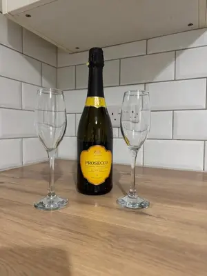a bottle of wine and two wine glasses on a table at Rowe Terrace Workington in Workington