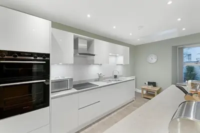 a kitchen with white appliances and a large window at 1 Harney Peak in Portinscale
