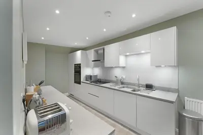 a kitchen with white cabinets and a toaster at 1 Harney Peak in Portinscale
