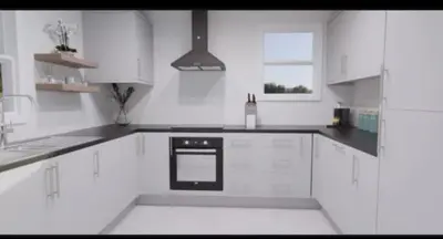 a white kitchen with white cabinets and a black oven at Pecklewell lodge in Ellenborough