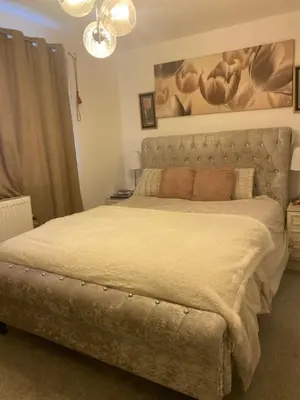 a bedroom with a large bed with a large headboard at Pecklewell lodge in Ellenborough