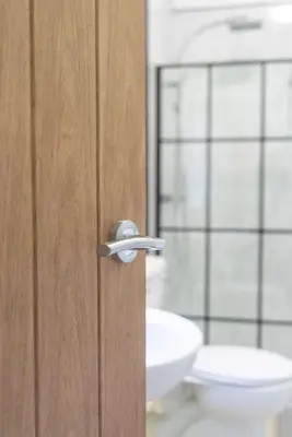 a bathroom with a wooden door with a sink at The Woodrouffee retreat in Carlisle
