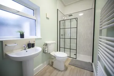 a bathroom with a toilet and a sink and a shower at The Woodrouffee retreat in Carlisle