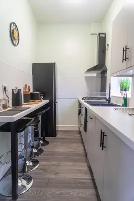 a kitchen with white counters and a black refrigerator at The Woodrouffee retreat in Carlisle