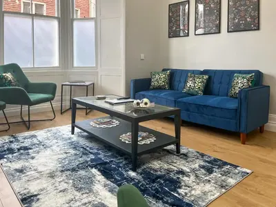 a living room with a blue couch and a table at Lakes And Shores Retreat in Maryport