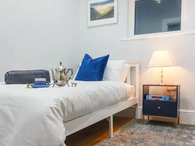 a bedroom with a white bed with blue pillows at Lakes And Shores Retreat in Maryport