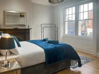 a bedroom with a large bed with a blue blanket at Lakes And Shores Retreat in Maryport