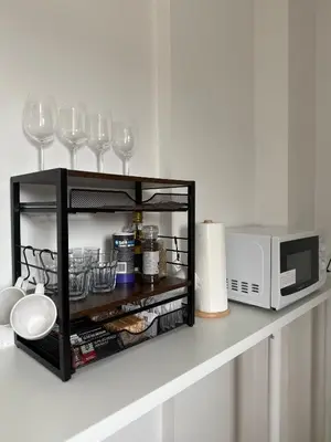 a shelf with wine glasses and a microwave on a counter at Private Rooms Near Acton Main Line Direct Elizabeth Line to Heathrow in Moffat