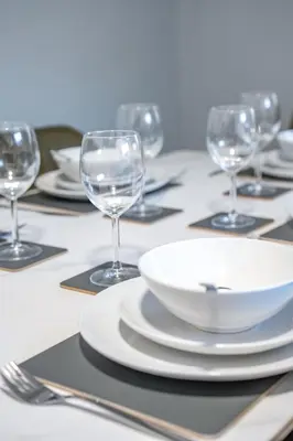a table with plates and wine glasses on it at Victory House in Gretna