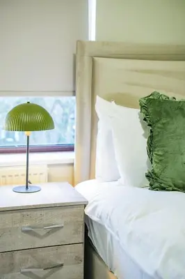 a bedroom with a bed with a lamp on a dresser at Victory House in Gretna