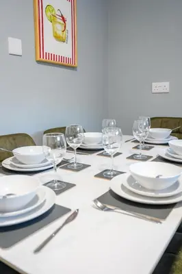 a table with white plates and wine glasses on it at Victory House in Gretna