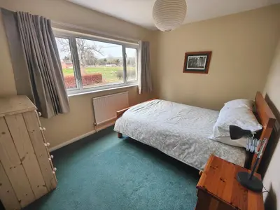 a bedroom with a bed and a window at Cozy cottage at the base of Sale and Ling Fell in Embleton