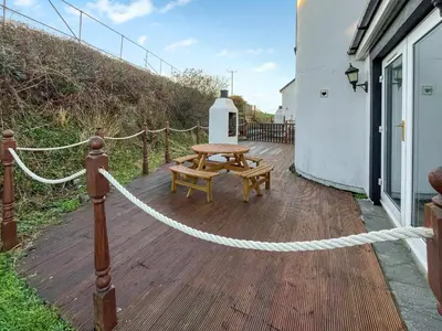 a wooden deck with a picnic table and a rope at Graeme-An-Taoiseach Uk50061 in Stranraer