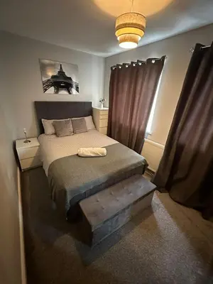 a bedroom with a bed with a wooden foot board at Ella's Place in Moffat