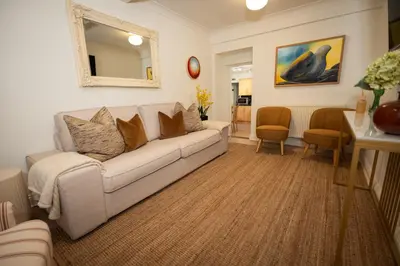 a living room with a couch and a mirror at River View Cottages in Annan