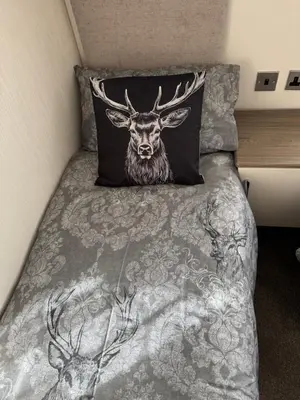 a bed with a picture of a deer on it at Turnberry Holiday Park Amazing Sea View in Girvan
