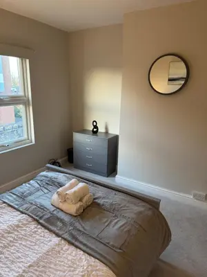 a bedroom with a bed with a mirror and a dresser at Work-Ready House Near Sellafield in Cleator Moor