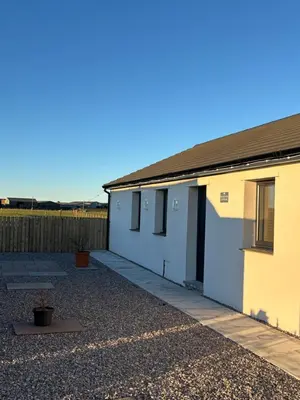 a small white building with a driveway at Black Dub Cottage in Allonby