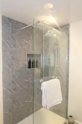 a shower with a glass door and a towel at Luxury one bedroom apartment in Dumfries