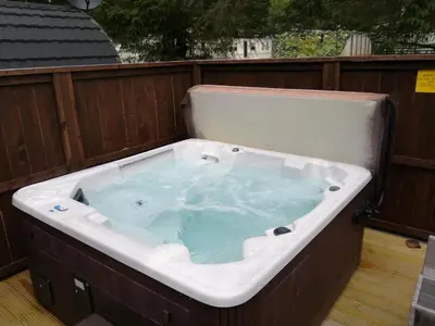 a jacuzzi tub sitting on top of a deck at Barrhill Holiday Park - Glamping in South West Scotland - Duisk in Girvan