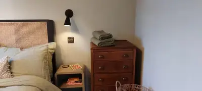a bedroom with a bed and a dresser with a phone at Cosy Cottage in Charming Village Close to Beach - Pass the Keys in Kirkbean