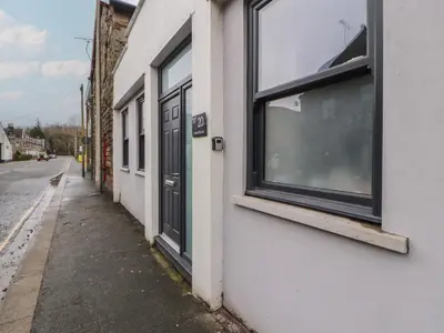a white building with windows on the side of a street at 20 Lorton Street in Cockermouth