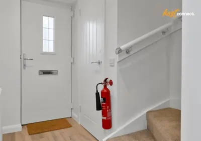 a fire extinguisher hanging on a wall next to a door at 2 Bed Flat in Airdrie I Sleeps 4 I Parking in Moffat