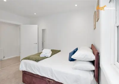 a bedroom with a bed with white sheets and pillows at 2 Bed Flat in Airdrie I Sleeps 4 I Parking in Moffat