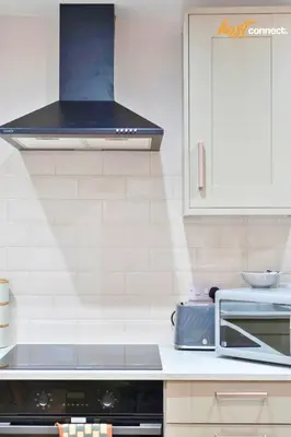 a kitchen with white cabinets and a stove top oven at 2 Bed Flat in Airdrie I Sleeps 4 I Parking in Moffat
