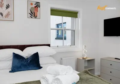 a bedroom with a bed with towels on it at 2 Bed Flat in Airdrie I Sleeps 4 I Parking in Moffat