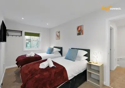 two beds in a room with white walls at 2 Bed Flat in Airdrie I Sleeps 4 I Parking in Moffat