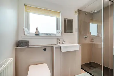 a bathroom with a sink and a toilet and a window at 1 Bed in Gatehouse Of Fleet oc-t34445 in Gatehouse of Fleet