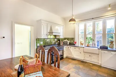 a kitchen with white cabinets and a wooden table at 4 Bed in Great Clifton oc-r34663 in Great Clifton