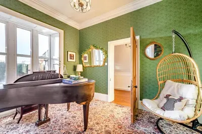 a room with a piano and a room with green walls at 4 Bed in Great Clifton oc-r34663 in Great Clifton