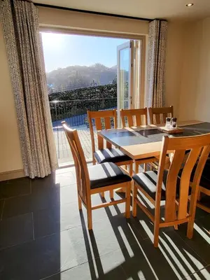 a dining room with a table and chairs and a large window at Wetherlam View Little Langdale in Little Langdale