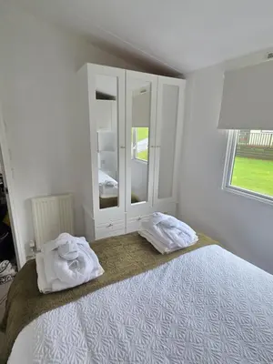a bedroom with a bed with two towels on it at Noah's Luxe Retreats in Newton Stewart