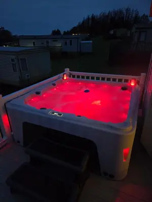 a hot tub with red lights in a backyard at Noah's Luxe Retreats in Newton Stewart