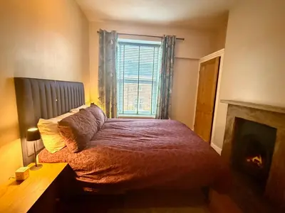 a bedroom with a bed with a fireplace and a window at The old townhouse in Carlisle