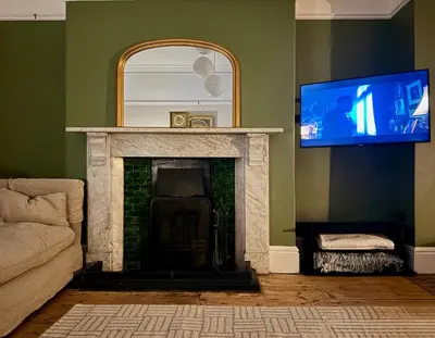 a living room with a fireplace and a flat screen tv at The old townhouse in Carlisle