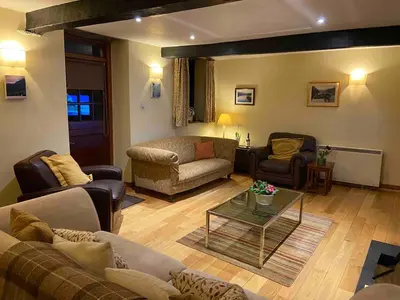a living room with couches and a coffee table at 3 Millbeck Cottage in Keswick